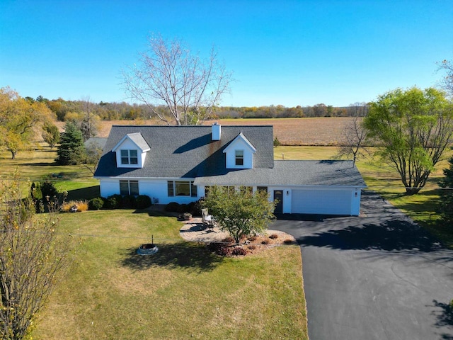 cape cod house featuring aphalt driveway, a rural view, an attached garage, a chimney, and a front yard