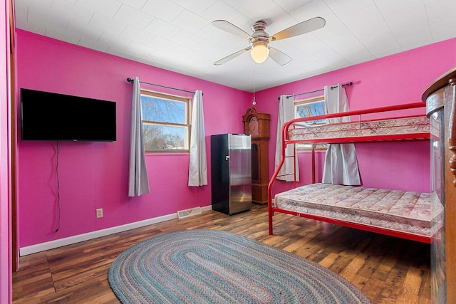 bedroom with a ceiling fan, baseboards, visible vents, and dark wood-style flooring