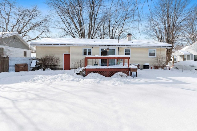 snow covered house with a wooden deck