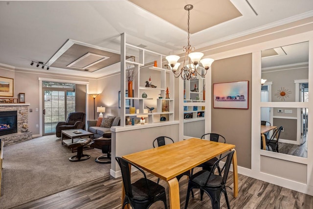 dining room with baseboards, a stone fireplace, dark wood finished floors, and crown molding