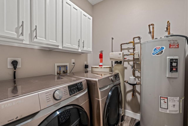 washroom with independent washer and dryer, baseboards, cabinet space, and electric water heater