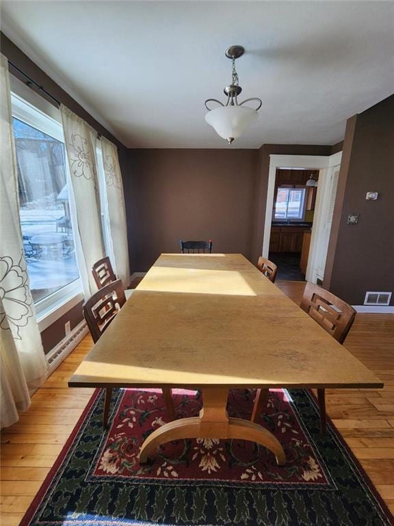 dining area featuring visible vents and wood finished floors