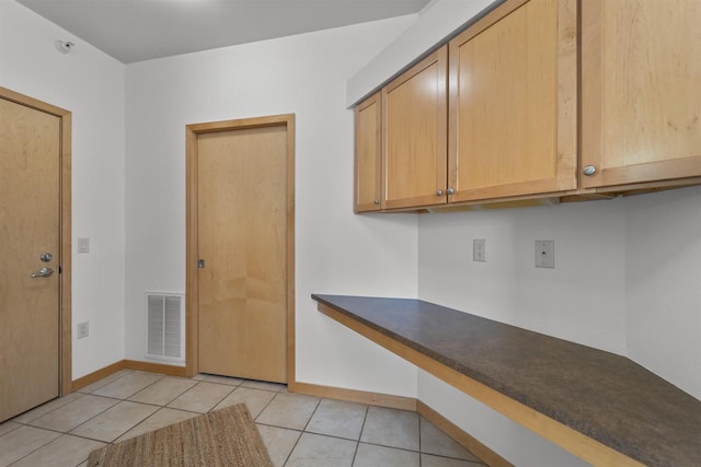 kitchen featuring dark countertops, visible vents, baseboards, and light tile patterned flooring