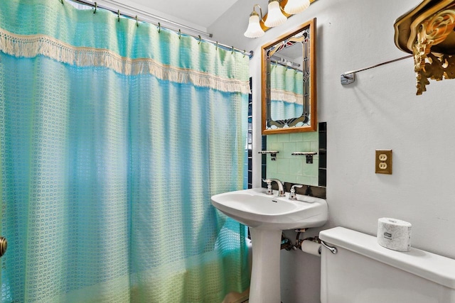 bathroom featuring backsplash and toilet