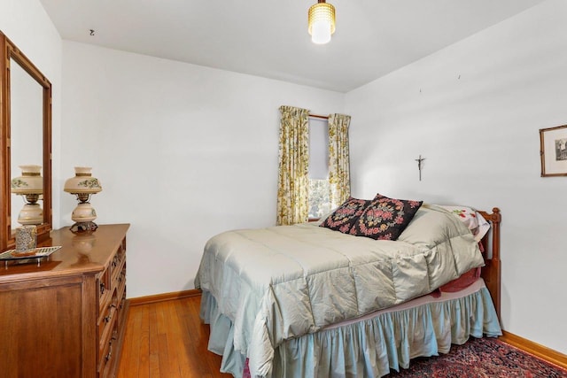 bedroom featuring baseboards and wood finished floors