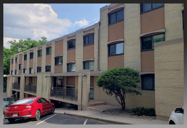 view of building exterior featuring uncovered parking