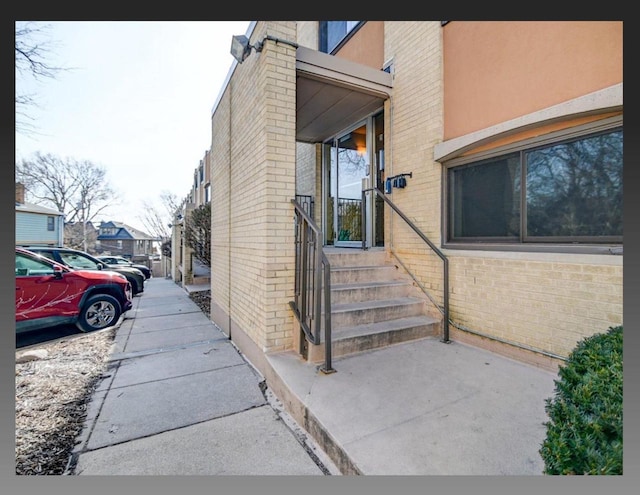 doorway to property featuring brick siding