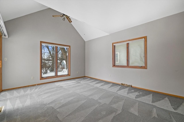 spare room featuring high vaulted ceiling, baseboards, a ceiling fan, and light colored carpet