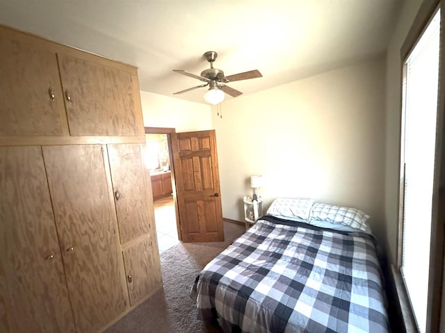 carpeted bedroom with a ceiling fan and baseboards