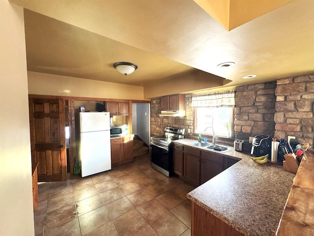 kitchen featuring decorative backsplash, brown cabinets, stainless steel appliances, under cabinet range hood, and a sink