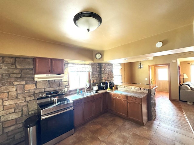 kitchen featuring electric range, open floor plan, a peninsula, under cabinet range hood, and a sink