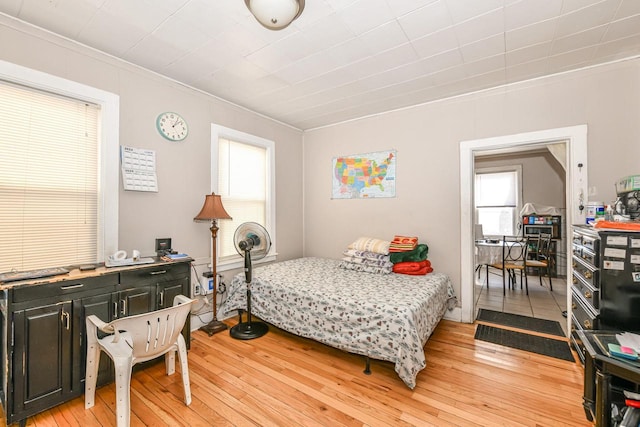 bedroom with crown molding and light wood-style floors