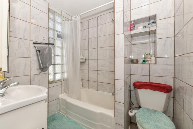 full bathroom with toilet, shower / tub combo, vanity, and tile walls