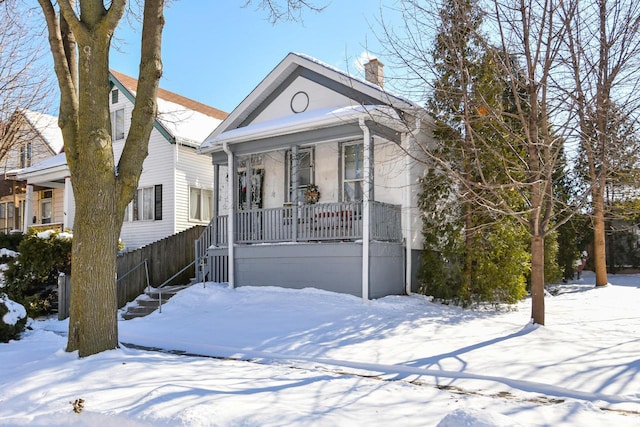 view of front facade featuring a chimney and fence