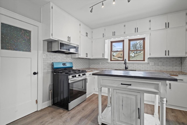 kitchen with appliances with stainless steel finishes, white cabinets, and a sink