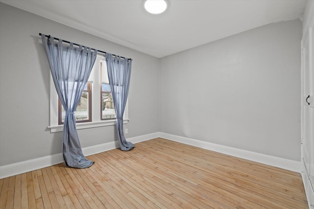 empty room with baseboards and light wood-style floors