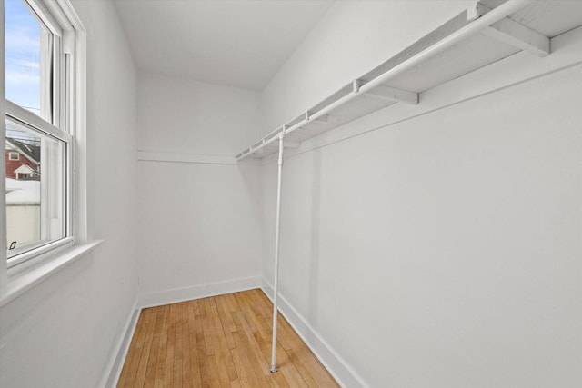 walk in closet with wood finished floors