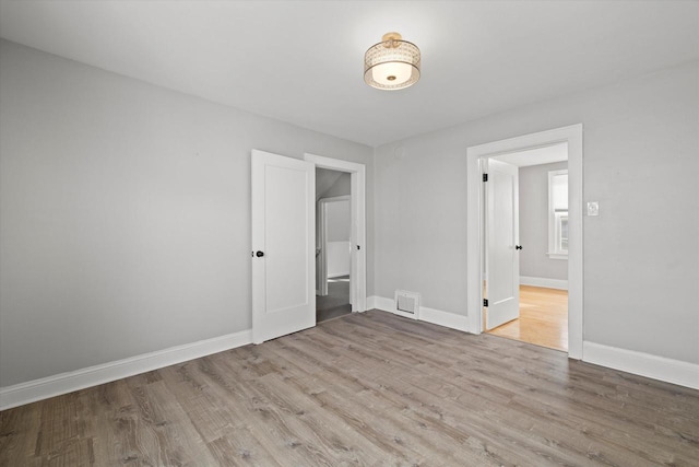 unfurnished bedroom featuring light wood-style flooring, visible vents, and baseboards