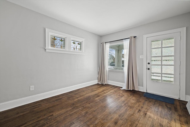 doorway with baseboards and dark wood finished floors