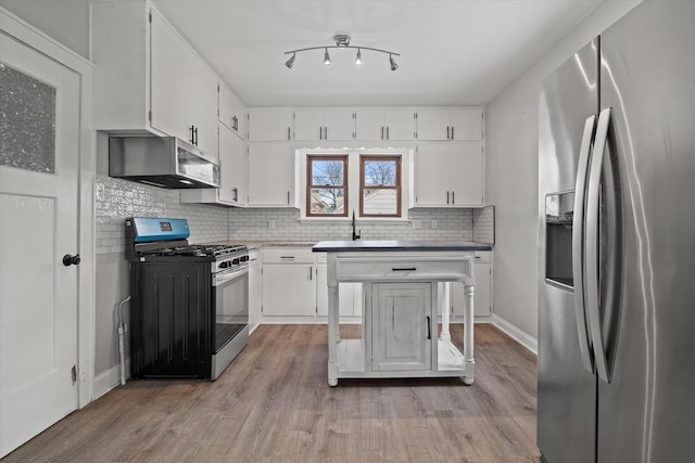 kitchen featuring stainless steel appliances, ventilation hood, and white cabinets