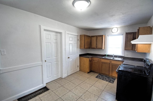 kitchen featuring electric range, visible vents, brown cabinets, under cabinet range hood, and a sink