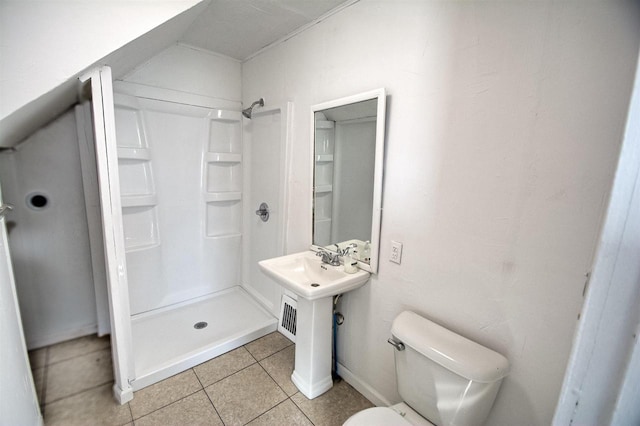 bathroom with tile patterned flooring, a shower stall, and toilet