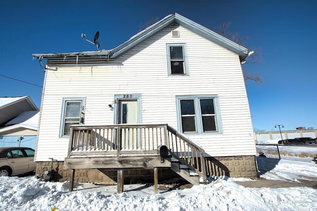 snow covered property with a deck