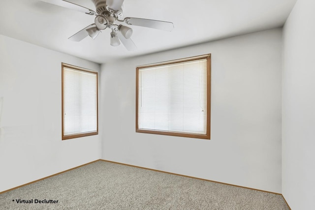 carpeted spare room with baseboards and a ceiling fan