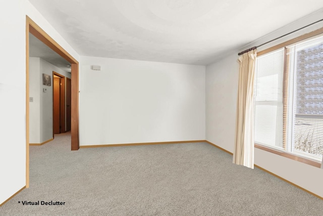 spare room with light carpet and baseboards