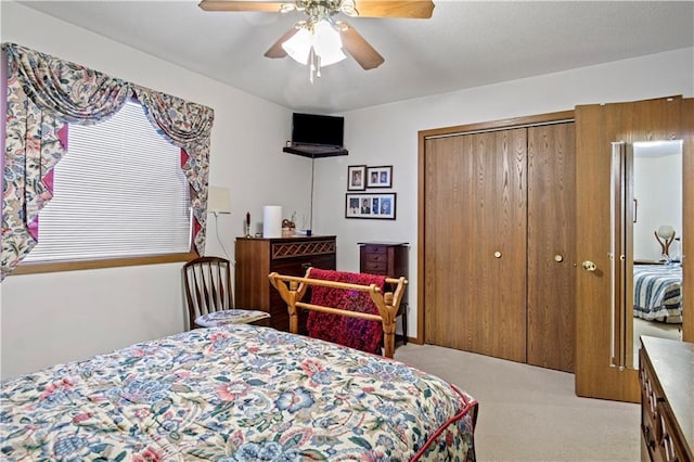 bedroom featuring ceiling fan, a closet, and light colored carpet