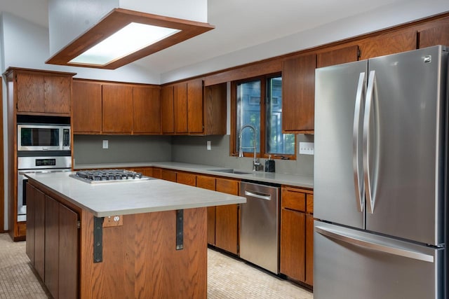 1725 Old Oak Ct, Brookfield, WI 53005 - kitchen with appliances with stainless steel finishes, brown cabinetry, light countertops, and a kitchen island