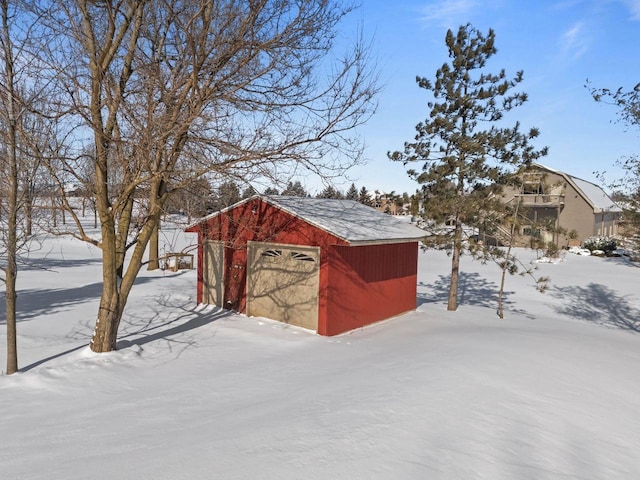 snow covered structure featuring an outbuilding