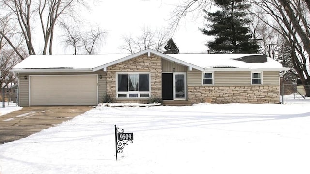 view of front facade featuring a garage, concrete driveway, stone siding, and fence