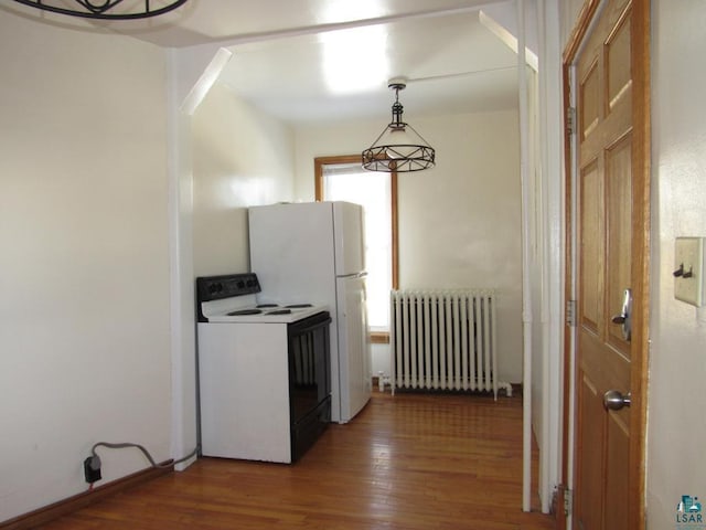 kitchen with radiator heating unit, pendant lighting, electric stove, and wood finished floors