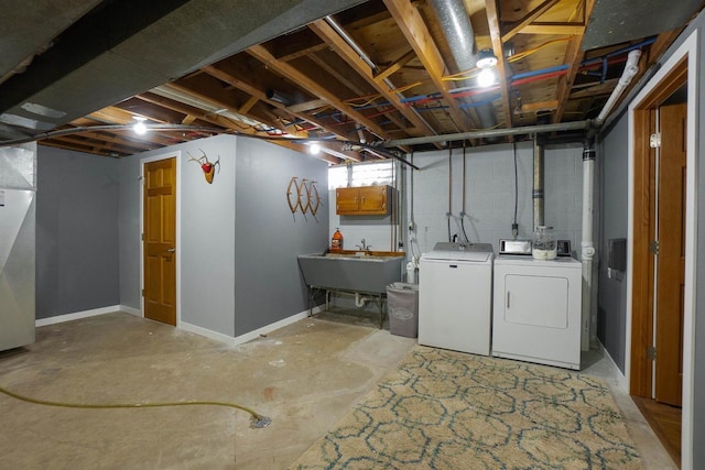 below grade area featuring washing machine and dryer, a sink, and baseboards