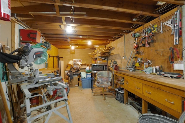 unfinished below grade area featuring concrete block wall and a workshop area