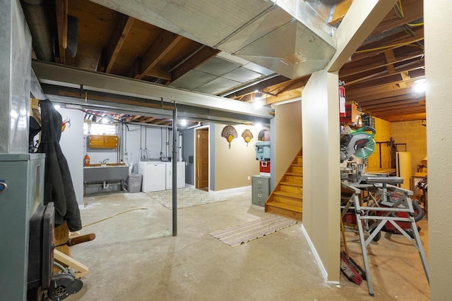 unfinished basement with stairway, independent washer and dryer, and a sink