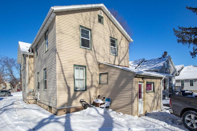 view of snow covered rear of property