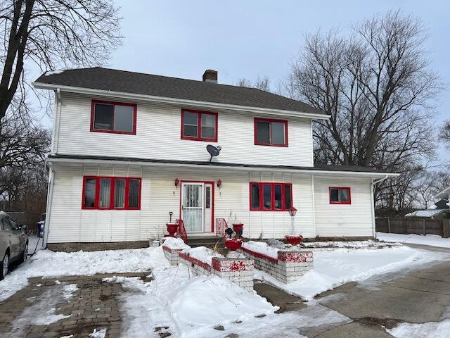 traditional-style house featuring entry steps and a chimney