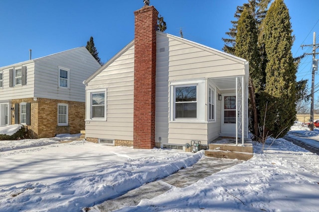 view of snow covered exterior featuring a chimney