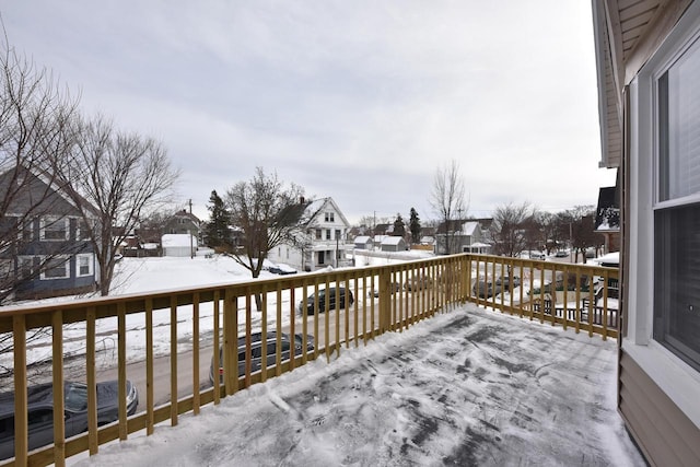 snow covered deck featuring a residential view