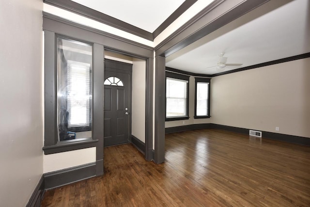 entryway featuring baseboards, visible vents, dark wood-style flooring, and ornamental molding