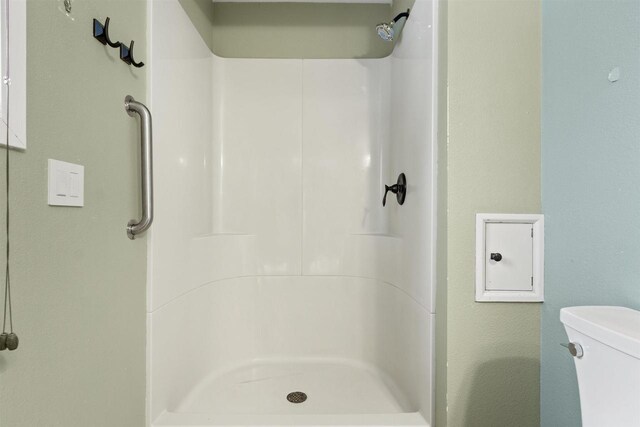 bathroom featuring a shower stall and toilet