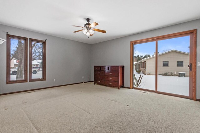 spare room with carpet floors, visible vents, baseboards, and a ceiling fan