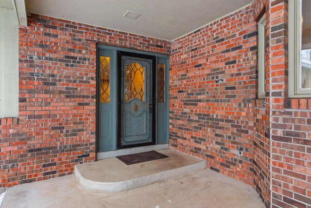 property entrance featuring brick siding