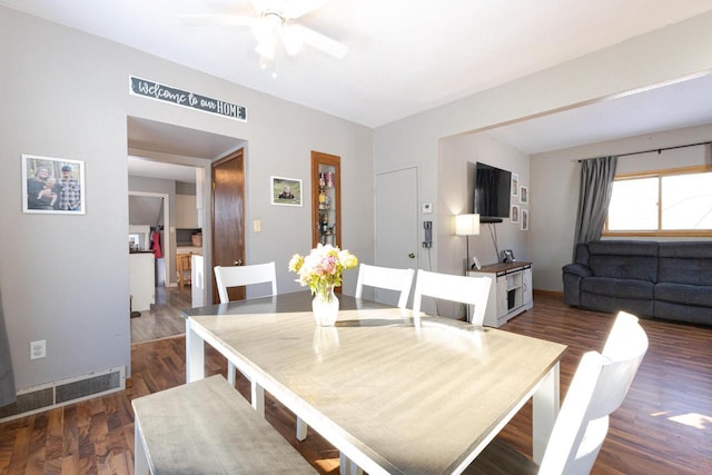 dining space with visible vents, dark wood finished floors, baseboards, and ceiling fan