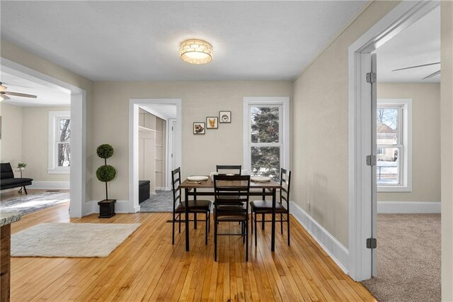 dining room with light wood-style flooring, baseboards, and a ceiling fan