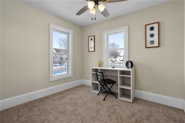 office featuring light colored carpet, plenty of natural light, baseboards, and ceiling fan