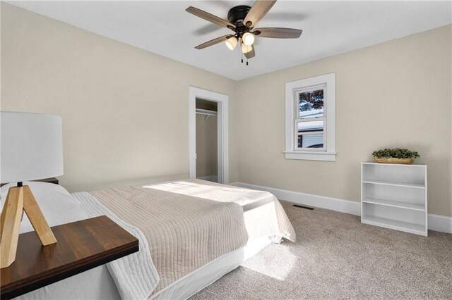 carpeted bedroom with a ceiling fan, visible vents, baseboards, and a closet