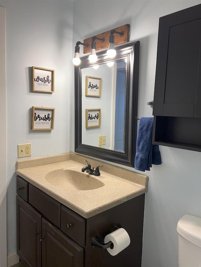 half bathroom featuring toilet and vanity